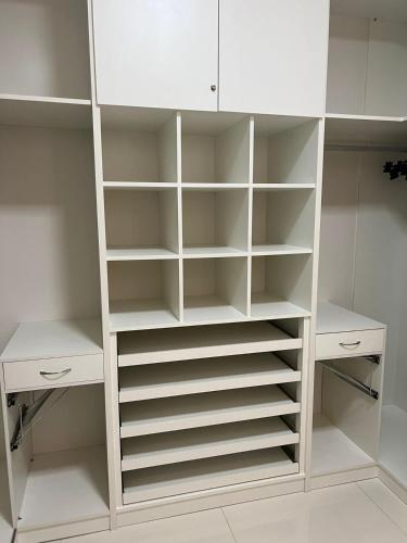 a white closet with white shelves and cabinets at River X House in Manaus