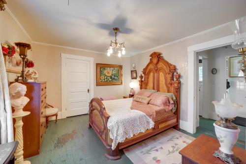 een slaapkamer met een groot bed en een kroonluchter bij Historic Fort Smith Cottage Less Than 1 Mi to Downtown! in Fort Smith