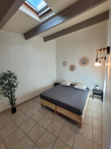 une chambre avec un lit et une lucarne dans l'établissement Le Rempart, à Saint-Mitre-les-Remparts