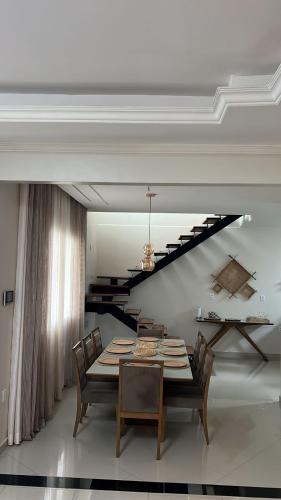 a dining room with a table and chairs and a staircase at River X House in Manaus
