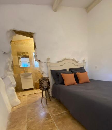 une chambre avec un grand lit avec des oreillers orange dans l'établissement BERGERIE A Murta, Domaine de l Ogliastru, à Olmeto