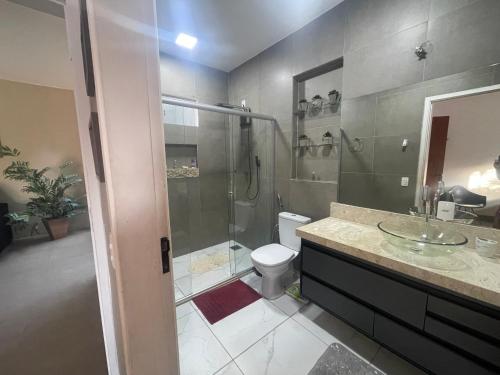 a bathroom with a shower and a toilet and a sink at Casa Bela no Rita Vieira in Campo Grande