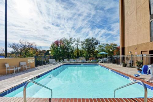 a swimming pool with chairs and a building at Hampton Inn Charlotte-Gastonia in Gastonia