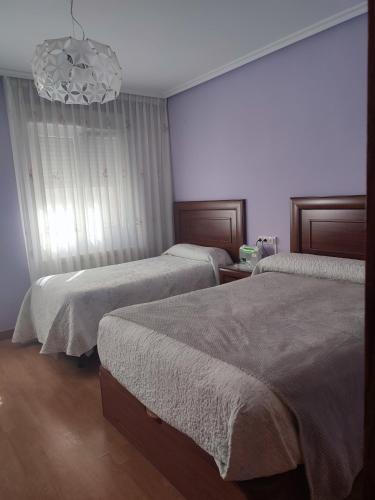 ヒホンにあるPrecioso piso en Gijónのベッドルーム1室(ベッド2台、シャンデリア付)