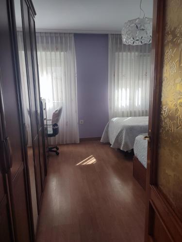 ヒホンにあるPrecioso piso en Gijónのベッドルーム1室(ベッド1台、デスク、窓付)