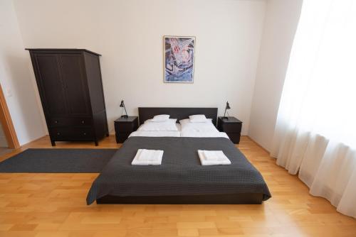 a bedroom with two beds and a dresser in it at Lakeside Heritage Apartment in Balatonfüred