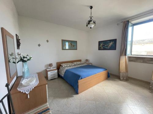 una camera con letto, tavolo e finestra di Bilocale al centro del Salento a Muro Leccese