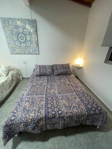een slaapkamer met een groot bed en een blauw dekbed bij Apartamento Completo 601 in Medellín