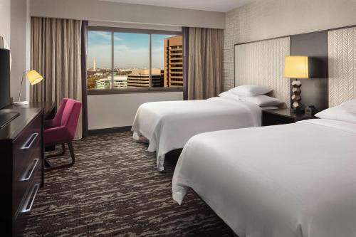 a hotel room with two beds and a window at Embassy Suites by Hilton Crystal City National Airport in Arlington