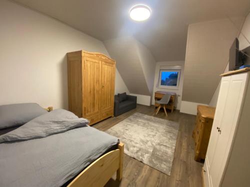 拜羅伊特的住宿－Colmdorf Ferienhaus，一间卧室配有一张床和一个木制橱柜