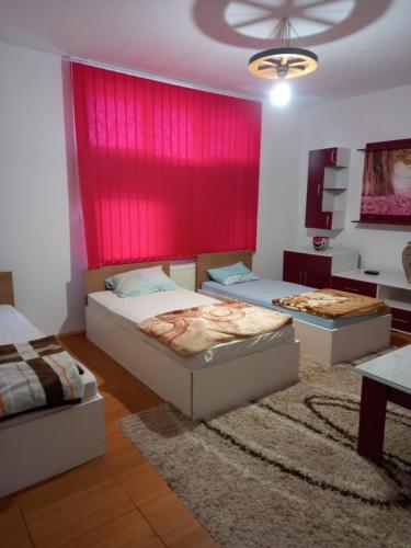 1 dormitorio con 2 camas y pared roja en Arthur 2 en Brčko