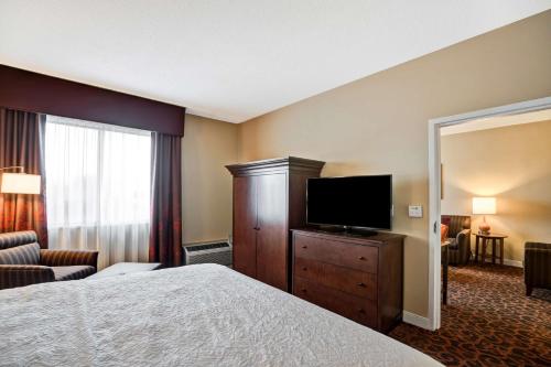 a hotel room with a bed and a flat screen tv at Hampton Inn Baltimore/Glen Burnie in Glen Burnie