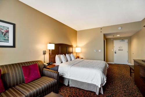 um quarto de hotel com uma cama e um sofá em Hampton Inn Baltimore/Glen Burnie em Glen Burnie