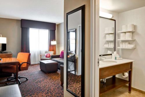 Hampton Inn Baltimore/Glen Burnie في غلين بورني: غرفة في الفندق مع حوض وغرفة معيشة