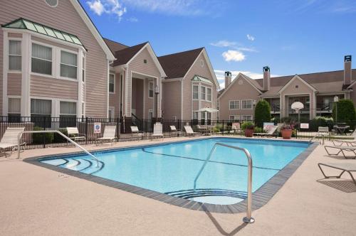 uma piscina em frente a um complexo de apartamentos em Homewood Suites by Hilton Windsor Locks Hartford em Windsor Locks