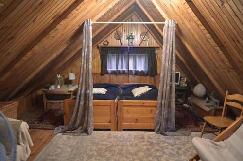 a bedroom with a bed in a attic at Ostoja dom letniskowy in Dzwonkowice