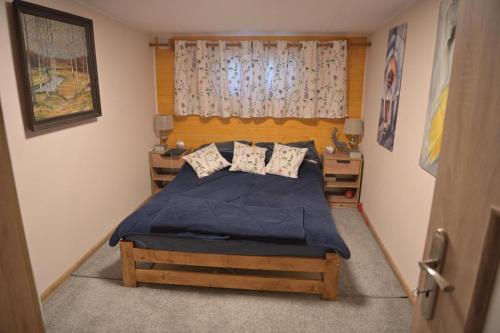 a bedroom with a bed with a blue comforter and pillows at Ostoja dom letniskowy in Dzwonkowice