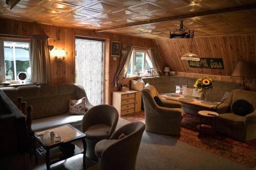 ein Wohnzimmer mit einem Sofa, einem Tisch und Stühlen in der Unterkunft Ostoja dom letniskowy 