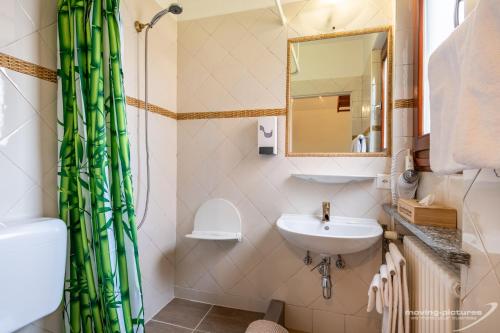 een badkamer met een wastafel en een douchegordijn bij Bamboohouse Motel Riazzino in Riazzino