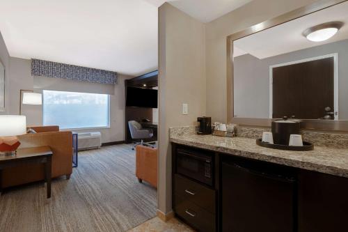 Habitación de hotel con tocador y espejo grande. en Hampton Inn & Suites Seattle/Federal Way en Federal Way