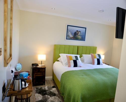 um quarto com 2 camas e uma cabeceira verde em Tu Guesthouse em Stanley