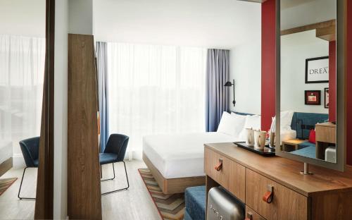 a hotel room with a bedroom with a bed and a tv at Hampton By Hilton Dublin City Centre in Dublin
