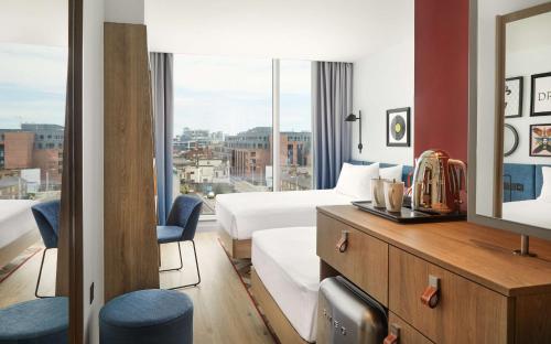 pokój hotelowy z łóżkiem i dużym oknem w obiekcie Hampton By Hilton Dublin City Centre w Dublinie