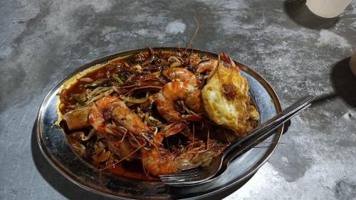 a plate of food with shrimp on a table at Sabai Sabai Guesthouse in Bayan Lepas in Bayan Lepas
