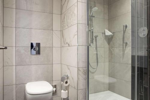 y baño con ducha y aseo. en Hilton Dublin Kilmainham en Dublín