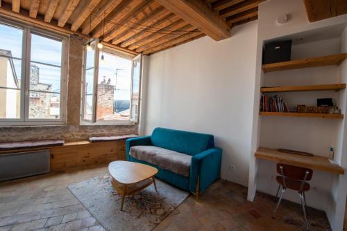 - un salon avec un canapé bleu et une table dans l'établissement Nid de l'Opéra, à Lyon