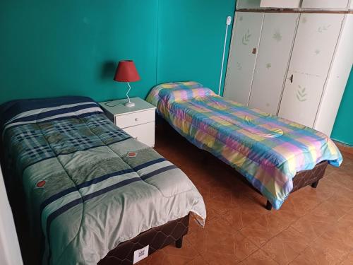 1 dormitorio con 2 camas y mesita de noche con lámpara en Lo de ines en Salta