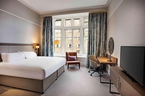 a hotel room with a bed and a television at Hilton Edinburgh Carlton in Edinburgh