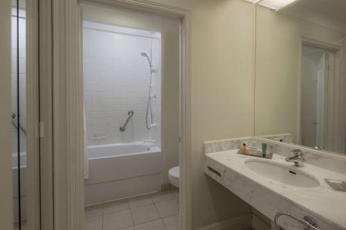 a bathroom with a sink and a tub and a toilet at Hilton Leicester Hotel in Leicester