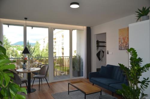 Apartment Hemsen في بريشوف: غرفة معيشة مع أريكة زرقاء وطاولة