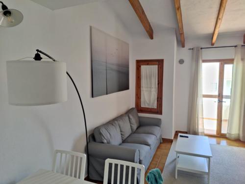 a living room with a couch and a table at Biniplaya - Apartamento reformado al lado de la playa in Arenal d'en Castell