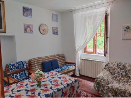 un salon avec un canapé, une table et une fenêtre dans l'établissement Camera mezzo montagna, à San Bartolomeo