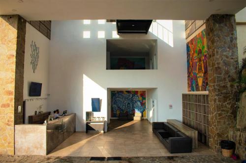 a lobby of a building with a wall with paintings at Coral Blue Huatulco in Santa Cruz Huatulco