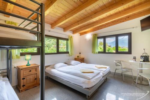 ein Schlafzimmer mit einem Etagenbett und einem Schreibtisch in der Unterkunft Bamboohouse Motel Riazzino in Riazzino