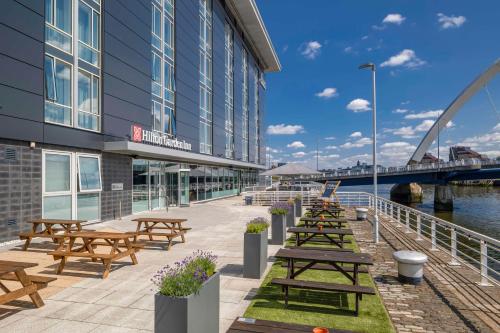 a row of picnic tables in front of a building at Hilton Garden Inn Glasgow City Centre in Glasgow
