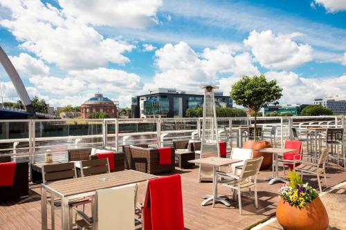 a deck with tables and chairs on a ship at Hilton Garden Inn Glasgow City Centre in Glasgow