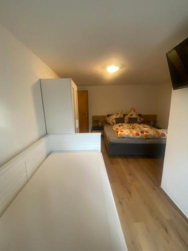 Kleines Zimmer mit einem Bett und einem Kühlschrank. in der Unterkunft Haus Bergfriede 2 in Obsteig