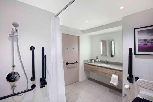 y baño con cortina de ducha y lavamanos. en DoubleTree by Hilton Glasgow Central en Glasgow