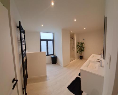 a white bathroom with a sink and a mirror at Huis ALNA 2 in Mechelen