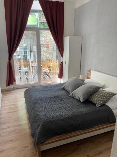 a bedroom with a bed and a large window at Schöne Wohnung mitten in Linz in Linz am Rhein