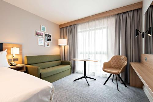 a hotel room with a bed and a couch and a table at Hilton Garden Inn Abingdon Oxford in Abingdon