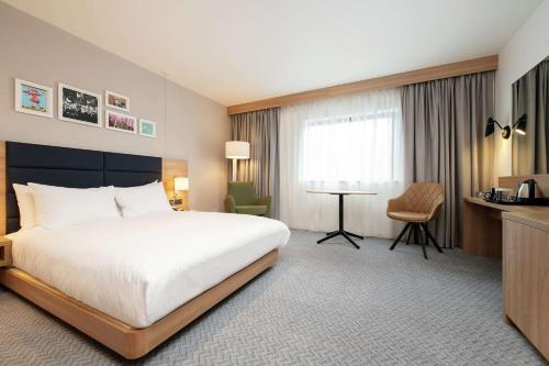 um quarto de hotel com uma cama grande e uma secretária em Hilton Garden Inn Abingdon Oxford em Abingdon