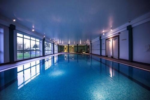 uma piscina com água azul num edifício em DoubleTree by Hilton Cheltenham em Cheltenham