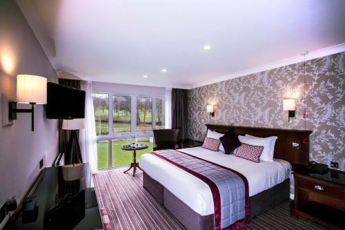 a hotel room with a bed and a television at DoubleTree by Hilton Cheltenham-Cotswolds in Cheltenham