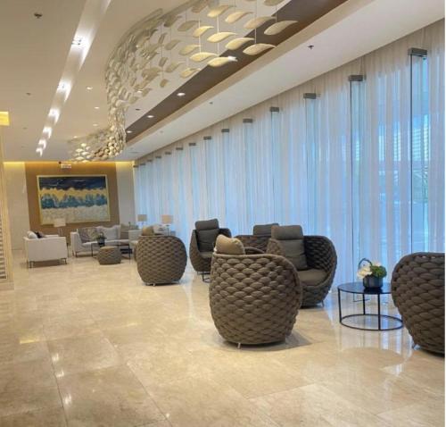 a lobby with couches and chairs in a building at MOA Pasay, Shore 3 Residences - Modern Luxury Condo in Manila