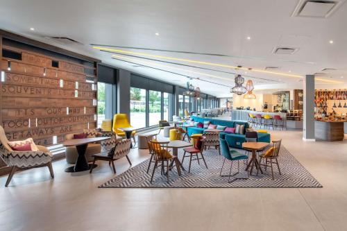 a restaurant with colorful chairs and tables in a cafeteria at Hampton by Hilton High Wycombe in High Wycombe